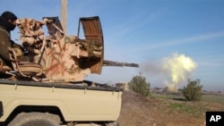 FILE - The Islamic State group recruits online. Here, a fighter fires a heavy weapon in Tal Tamr, Syria, in an image posted on a social media account by the group's Al-Baraka division, Feb. 24, 2015.