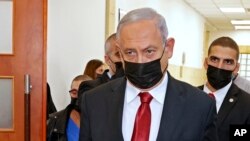 Mantan Perdana Menteri Israel Benjamin Netanyahu berjalan meninggalkan Pengadilan Yerusalem pada 16 November 2021, setelah menghadiri persidangan kasus korupsi yang melibatkan dirinya. (Foto: Pool via AP/Jack Guez)