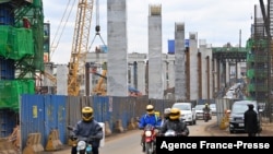 资料照片：驾车者在蒙巴萨公路上行驶，旁边是正在施工的内罗毕高速公路，由中国路桥公司承建。(2021年7月12日)