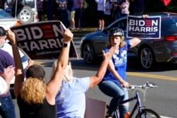 Supporters of President-elect Joe Biden wave signs at the entrance to Trump National Golf Club in Sterling, Va., Nov. 7, 2020. Trump was at the facility.