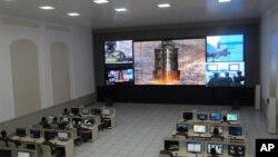 Ilmuwan dan teknisi pada Pusat Kontrol dan Komando Satelit di luar kota Pyongyang menyaksikan peluncuran roket. (Foto: AP)