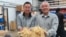 Will Hsu, left, and father Paul Hsu check out some ginseng at their processing center in north-central Wisconsin. (C. Guensburg/VOA)