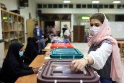 An Iranian woman casts her vote during the presidential election at a polling station in Tehran, Iran June 18, 2021.