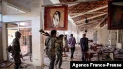 FILE - Fano fighters walk through a ransacked building in the Amhara region of Ethiopia, Dec. 7, 2021. Violence erupted March 1, 2024, between Ethiopian government forces and members of the militia.