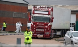 FILE - Police forensics officers attend the scene after a truck was found to contain the bodies of 39 refugees, in Thurrock, South England, Oct. 23, 2019.