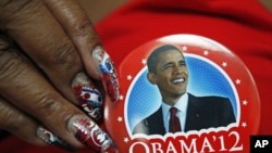 A delegate shows off her Barack Obama button in the convention hall before the Democratic National Convention in Charlotte, North Carolina, Sept. 3, 2012. 