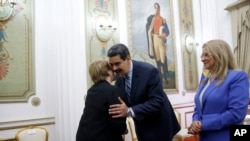 U.N. High Commissioner for Human Rights Michelle Bachelet, left, is greeted by Venezuela's President Nicolas Maduro, as first lady Cilia Flores looks on, at Miraflores Presidential Palace, in Caracas, Venezuela, Friday, June 21, 2019.