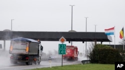 FILE - Trucks pass through an open border between Belgium and Luxembourg, two Schengen zone member countries, Feb. 4, 2016.