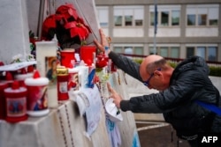 Seorang pria berdoa di depan patung Yohanes Paulus II di Rumah Sakit Universitas Gemelli tempat Paus Fransiskus dirawat karena pneumonia, di Roma pada 1 Maret 2025. (Foto: AFP)
