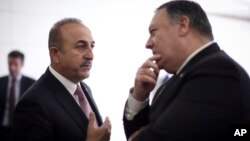 El ministro de Relaciones Exteriores de Turquía, Mevlut Cavusoglu conversa con el secretario de Estado de EE.UU., Mike Pompeo, en el aeropuerto de Esenboga en Ankara, Turquía, el 17 de octubre de 2018.