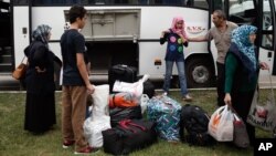 Syrian refugees prepare to board a bus for Istanbul, abandoning plans to cross to Europe near Turkey’s western border with Greece and Bulgaria, in Edirne, Turkey, Wednesday, Sept. 23, 2015.