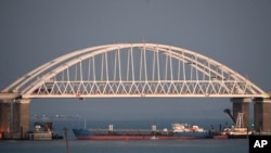 FILE - A Russian tanker under the Kerch bridge blocks the passage to the Kerch Strait near Kerch, Russia-annexed Crimea, Nov. 25, 2018. A Russian oil tanker carrying thousands of tons of oil products split apart during a heavy storm, Dec. 15, 2024.