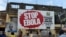 FILE - People walking past a billboard reading "Stop Ebola" in Freetown, Sierra Leone, Nov. 7, 2014. 