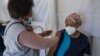 Un agent de santé administre un vaccin contenant le vaccin Pfizer sur un soignant de la maison de retraite SAVF Evanna Tehuis près de Klerksdorp, le 19 mai 2021.