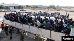 FILE - Migrants ride in a truck before they are transported to a detention center, in the coastal city of Sabratha, Libya, Oct. 7, 2017. 