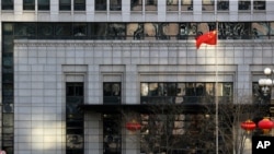 FILE - Paramilitary policemen perform exercises at China's Ministry of Commerce in Beijing, Feb. 11, 2019. 