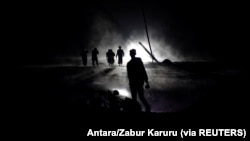 Warga menyusuri jalan yang tertutup abu vulkanik yang dimuntahkan Gunung Semeru di Desa Sumber Wuluh, Lumajang, Jawa Timur, 5 Desember 2021. (Foto: Antara/Zabur Karuru via REUTERS)