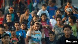 Hundreds of Central American migrants walk together on the highway, after crossing the Guatemala – Mexico border, near Ciudad Hidalgo, Mexico, June 5, 2019.