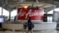 FILE - A woman walks past an AirAsia counter at Kuala Lumpur International Airport in Sepang, Malaysia, July 22, 2019. 