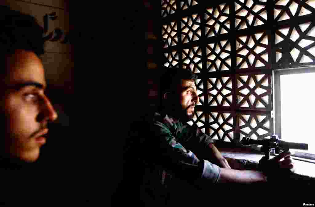 A Free Syrian Army fighter observes the area during clashes in Aleppo, August 16, 2012.