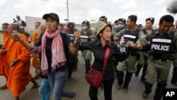 FILE - Cambodian civil rights supporters are forcibly directed by riot police as they march in protest of charges brought against local rights activists near Prey Sar prison, outside Phnom Penh, Cambodia, May 9, 2016.