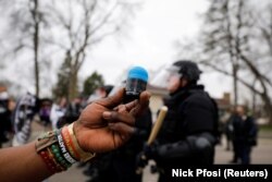 Un manifestant brandit la balle en caoutchouc qui l'a touché au côté lors d'une confrontation avec la police à Brooklyn Center, Minnesota, États-Unis, le 11 avril 2021.