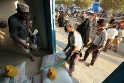 FILE - A worker carries a sack of wheat flour at a United Nations aid distribution center in Hodeidah, Yemen, Nov. 13, 2018.
