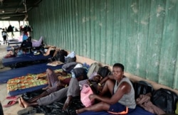 Migrants from African countries rest outside a barn used as a shelter in Peñitas, Darien Province, Panama, May 10, 2019. African and Asian migrants tend to pay smugglers to shepherd them through the Darien Gap on their journey north to the U.S.