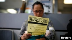Seorang warga membaca brosur Obamacare di Cudahy, California. (Foto: Dok)