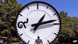 FILE - In this Thursday, July 25, 2019 photo, workers at the Electric Time Company in Medfield, Mass., test a 20 foot high clock, built for the a new train station in Bangkok, Thailand. (AP Photo/Charles Krupa)