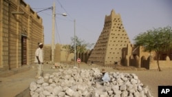 Men work alongside one of Timburktu's historic mud mosques, in Timbuktu, Mali. (file photo)