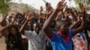 People displaced following attacks by Islamist militants raise their arms as they pass through security before casting their votes, in Yola, Nigeria, March 28, 2015.