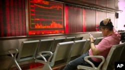 Seorang investor China memonitor pergerakan harga saham di sebuah kantor pialang saham di Beijing, 10 Mei 2019.
