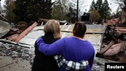 Irma Corona, right, comforts neighbor Gerryann Wulbern in front of the remains of Wulbern's home after the two returned for the first time since the Camp Fire in Paradise, Calif., Nov. 22, 2018.