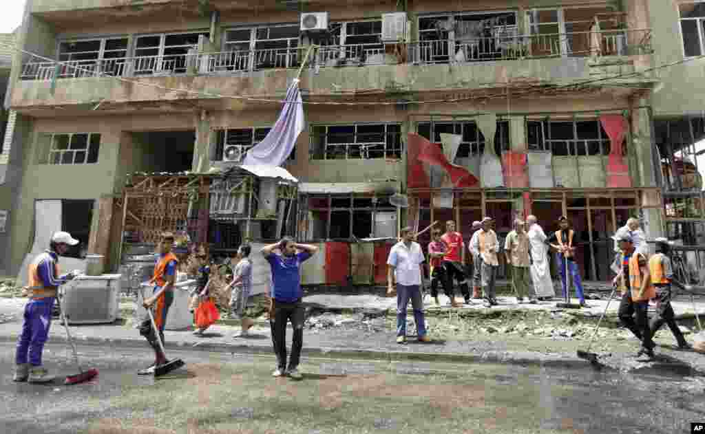 Baghdad municipality workers clean up while restaurant staff react after a car bomb exploded, Baghdad, May 30, 2013.