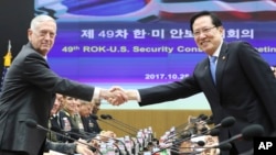 U.S. Defense Secretary Jim Mattis, left, and South Korean Defense Minister Song Young-moo shake hands while posing for a photo before the 49th Security Consultative Meeting at Defense Ministry in Seoul, South Korea, Oct. 28, 2017.