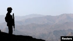 FILE - A Pakistani soldier stands guard along the border fence outside the Kitton outpost on the border with Afghanistan, in North Waziristan, Pakistan Oct. 18, 2017.