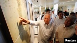 Ngoại trưởng Philippines Albert Del Rosario chỉ vào một bản đồ cổ trên màn hình bên cạnh Bộ trưởng Quốc phòng Voltaire Gazmin tại trường đại học Công giáo ở Manila, ngày 11/9/2014.