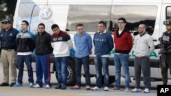 Polisi mengawal ketat tujuh orang yang didakwa terlibat dalam kasus pembunuhan agen DEA James "Terry" Watson di Bogota, Kolombia, sebelum diekstradiksi ke AS, 1 Juli 2014 (Foto: dok). 