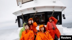 Tourists on a whale watching tour boat look for whales in the sea near Rausu, Hokkaido, Japan, July 1, 2019. 