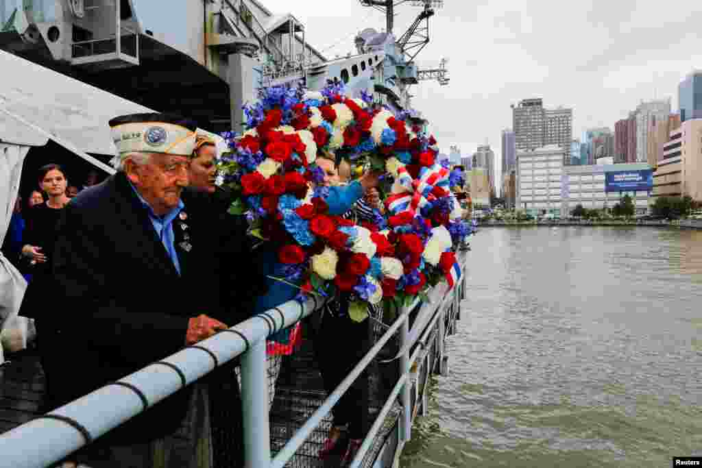 World War II veteran and Pearl Harbor survivor Armando "Chick" Galella (L) tosses a floral wreath following an annual Memorial Day commemoration ceremony at the Intrepid museum in New York, May 29, 2017.
