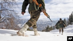 FILE - Indian army soldiers patrol near the Line of Control (LOC) that divides Kashmir between India and Pakistan, in Churunda village, India, Jan. 15, 2013.