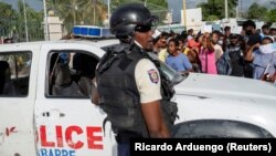Des agents de la police nationale haïtienne gardent l'entrée de l'ambassade des États-Unis alors que des personnes se rassemblent pour demander l'asile après l'assassinat du président Jovenel Moise, à Port-au-Prince, en Haïti, le 9 juillet 2021. 