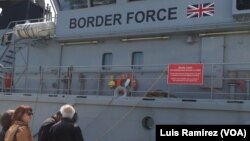 Residents of Lesbos peer into a British cutter that has been sent as part of a European Uunion force to assist Greece in returning migrants to Turkey, April 3, 2016.