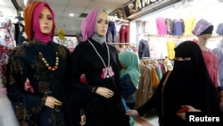 FILE - A woman wearing a full-face veil shops for clothes in a traditional textile market in Jakarta, Indonesia March 7, 2018. An Indonesian state Islamic university faced criticism this week after it barred female students from wearing full-face veils. (REUTERS/Willy Kurniawan)