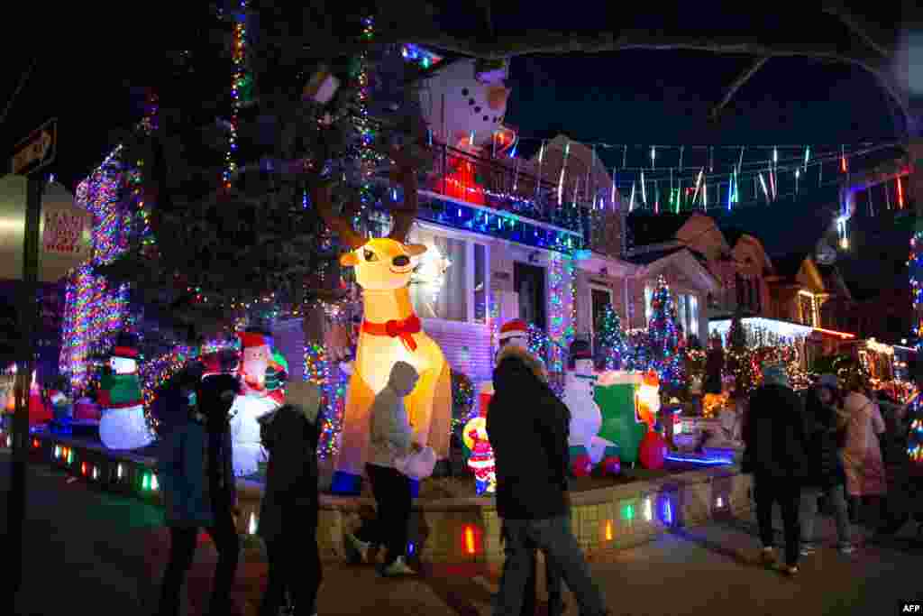 En el barrio iluminado de Dyker Heights de Brooklyn, ni siquiera una pandemia puede mantener a raya el espíritu festivo. Sin importar que en Nueva York se cancelaron las representaciones navideñas tradicionales. 15 de diciembre de 2020. [AFP]