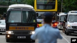 A prison van, left, which a police officer says is carrying Tong Ying-kit arrives at a court in Hong Kong, June 23, 2021. 