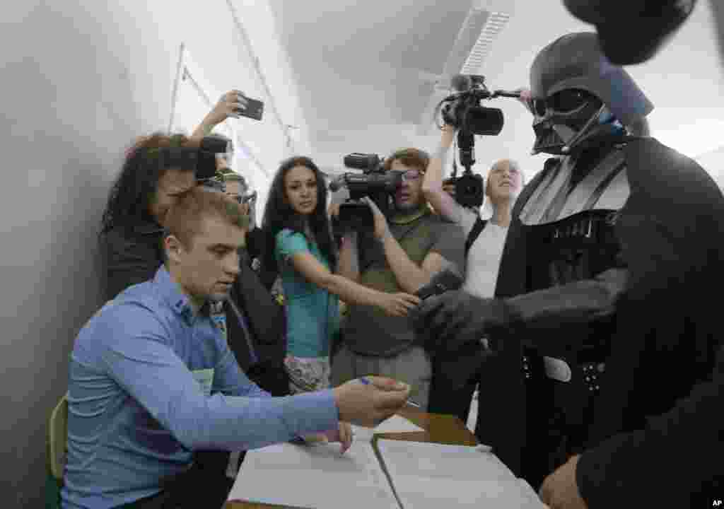 Darth Vader, the Ukrainian Internet Party candidate for Kyiv's mayor, waits to receive his ballot at a polling station in Kiev.