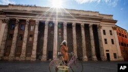 A woman walks in empty Piazza di Pietra square, in Rome, Wednesday, March 18, 2020. For most people, the new coronavirus causes only mild or moderate symptoms. 