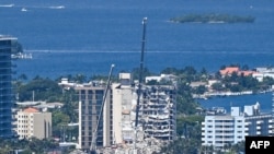 Cranes are seen at a partially collapsed building in Surfside, Florida, north of Miami Beach, on June 27, 2021.